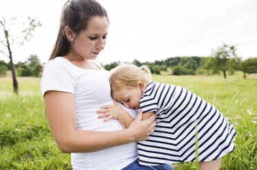 Little girl hugging pregnant mother's belly - HAPF000729