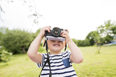 Little girl in park playing with camera - HAPF000730