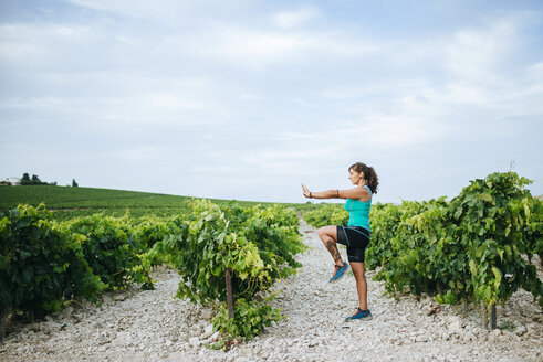 Frau macht Tai Chi in einem Weinberg - KIJF000726