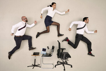 Bürokollegen, die über Stühle und Geräte springen - BAEF001077