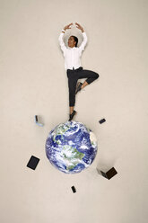 Businesswoman doing a pirouette on globe with mobile devices - BAEF001126