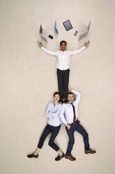 Zwei Geschäftsleute mit Kollegen, die mit mobilen Geräten jonglieren - BAEF001136