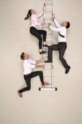 Drei Geschäftskollegen klettern die Leiter hinauf - BAEF001221