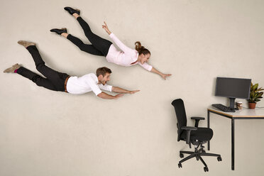 Geschäftskollegen fliegen auf den Schreibtisch zu - BAEF001226