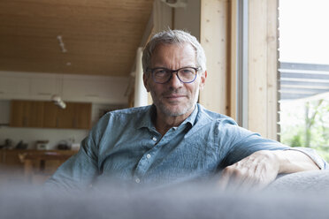 Portrait of confident mature man sitting on couch - RBF004859