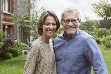 Porträt eines lächelnden reifen Paares im Garten - RBF004875