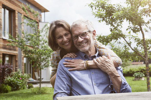 Porträt eines glücklichen reifen Paares im Garten, lizenzfreies Stockfoto