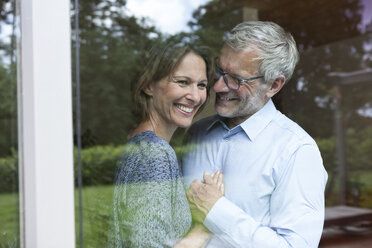 Happy mature couple behind windowpane - RBF004895