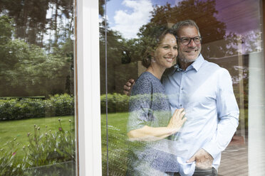 Lächelndes reifes Paar schaut aus dem Fenster - RBF004897