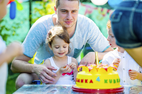 Kinder feiern Geburtstagsparty im Garten mit Freunden und Familie, lizenzfreies Stockfoto