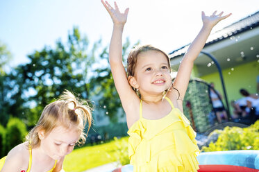 Kinder haben Spaß im Planschbecken im Garten - HAPF000754