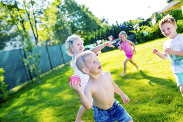 Kinder haben Spaß mit Wasserbomben im Garten - HAPF000762