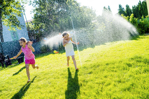 Kinder haben Spaß mit dem Rasensprenger im Garten - HAPF000766