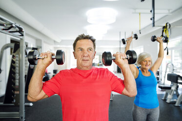 Älterer Mann und reife Frau trainieren im Fitnessstudio - HAPF000776
