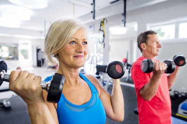 Ältere Frau und älterer Mann trainieren im Fitnessstudio - HAPF000777