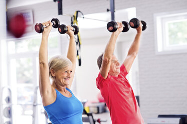 Ältere Frau und älterer Mann trainieren im Fitnessstudio - HAPF000780