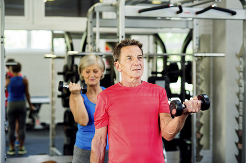 Älterer Mann und reife Frau trainieren im Fitnessstudio, lizenzfreies Stockfoto