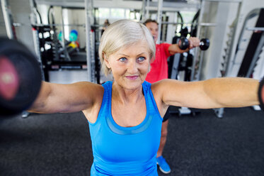 Mature woman and senior man working out in fitness gym stock photo
