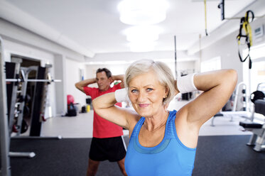 Mature woman and senior man doing gymnastics in fitness gym - HAPF000790