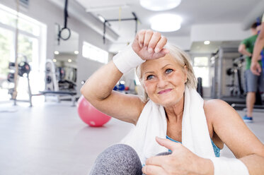 Smiling mature woman having a break in fitness gym - HAPF000796