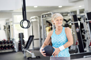 Ältere Frau hält Ball im Fitnessstudio - HAPF000807