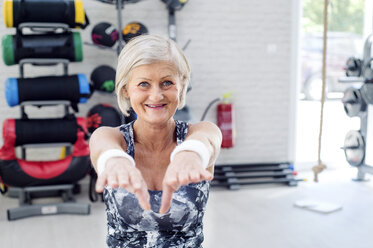 Smiling mature woman doing gymnastics in fitness gym - HAPF000809