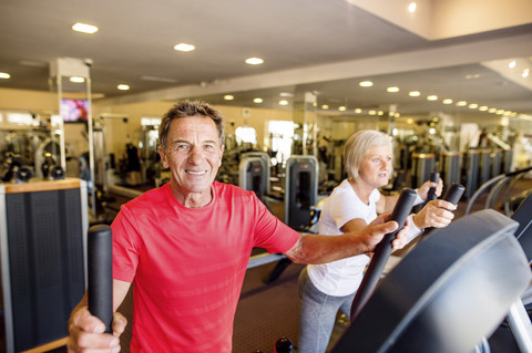 Älterer Mann und reife Frau auf Schritt Maschine im Fitnessstudio, lizenzfreies Stockfoto