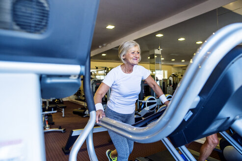 Ältere Frau beim Training auf dem Laufband im Fitnessstudio - HAPF000828