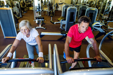Älterer Mann und reife Frau trainieren auf dem Laufband im Fitnessstudio - HAPF000829