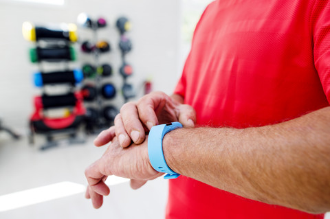 Mann im Fitnessstudio mit Smartwatch, lizenzfreies Stockfoto