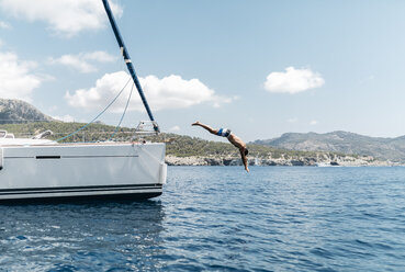 Mann springt von seinem Segelboot ins Meer - JRFF000828