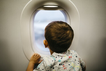 Little boy looking out of airplane window - JRFF000834