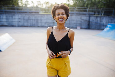 Portrait of smiling young woman in a skatepark - GIOF001403
