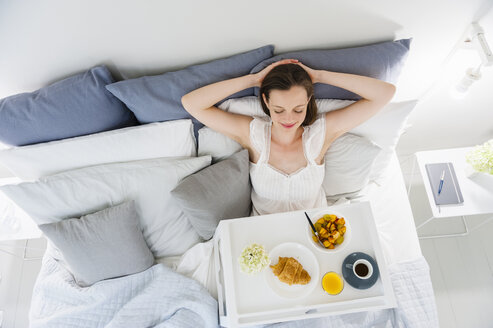 Frau im Bett sitzend mit Frühstückstablett - DIGF000952