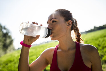 Italy, Tuscany, sportswoman drinking water - GIOF001443