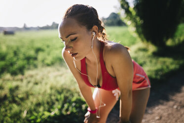 Italy, Tuscany, sportswoman, headphones, break - GIOF001451