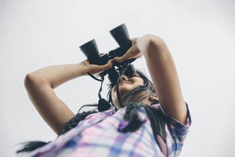 Frau schaut durch einen Feldstecher, lizenzfreies Stockfoto