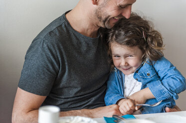 Father and daughter having fun at breakfast table - DIGF000963