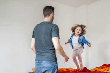 Vater sieht Tochter auf dem Bett hüpfen - DIGF000981