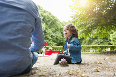 Vater spielt mit Tochter im Sandkasten - DIGF001018