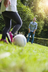 Father and daughter playing football in park - DIGF001023