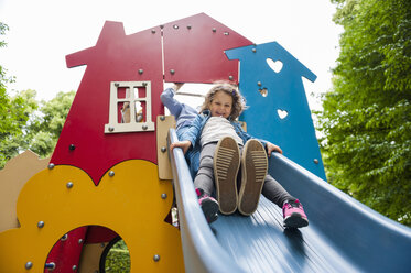 Vater mit Tochter auf Spielplatzrutsche - DIGF001026