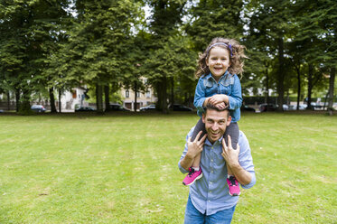 Father carrying daughter on shoulders in park - DIGF001033