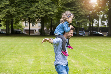 Father carrying daughter on shoulders in park - DIGF001035