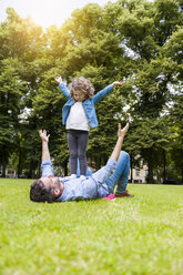 Vater und Tochter spielen auf einer Wiese im Park - DIGF001041