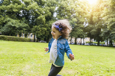 Glückliches Mädchen läuft auf einer Wiese im Park - DIGF001044