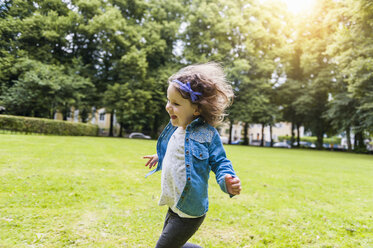 Happy girl running on meadow in park - DIGF001044