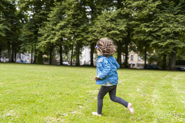Glückliches Mädchen läuft auf einer Wiese im Park - DIGF001045