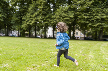 Happy girl running on meadow in park - DIGF001045