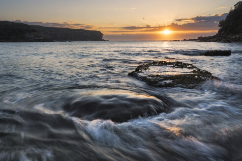 Australien, New South Wales, Meereslandschaft mit rauschendem Wasser und aufgehender Sonne im Gegenlicht, Wellen - GOAF000011